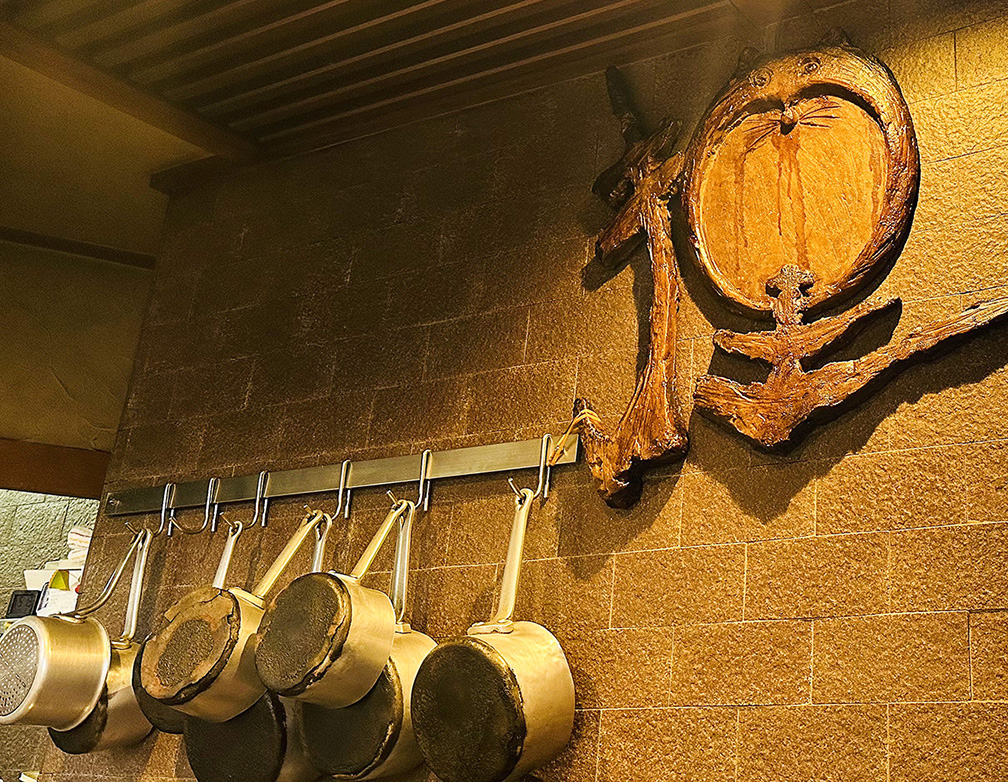 オープンキッチンと狸の装飾が印象的な店内